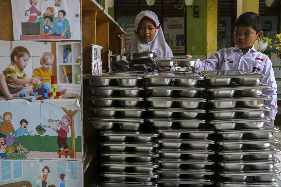 Image Credit Angga Budhiyanto/Antara - Children return the food trays used by the government-aided free meals at an elementary school in Banten on Feb. 18, 2025.