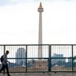 Image Credit Khaerul Izan/Antara - Residents when passing in front of the tugu Monas Jakarta on Friday (1/17/2025).