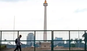 Image Credit Khaerul Izan/Antara - Residents when passing in front of the tugu Monas Jakarta on Friday (1/17/2025).