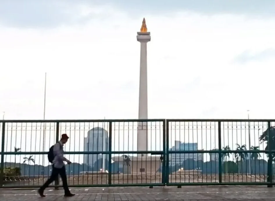 Image Credit Khaerul Izan/Antara - Residents when passing in front of the tugu Monas Jakarta on Friday (1/17/2025).